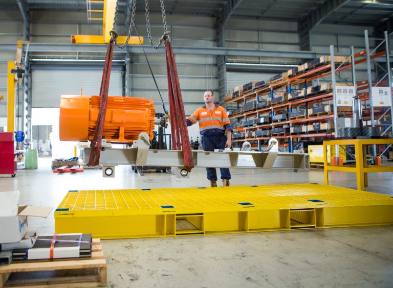 man placing heavy equipment on a steel pallet