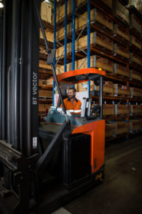man driving a forklift inside the warehouse
