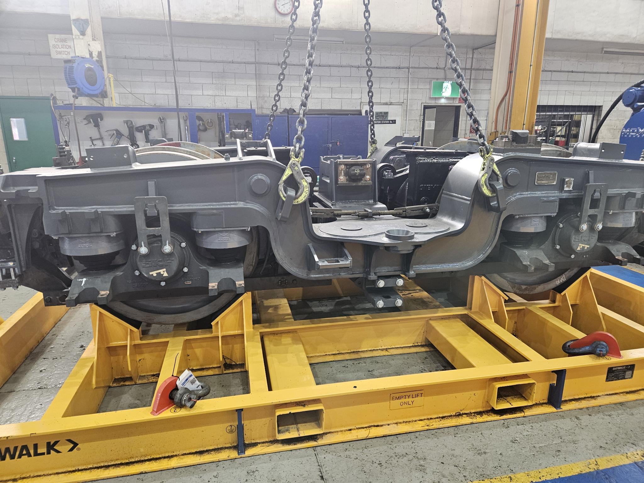 Rail bogie for mining being lowered onto transport frame
