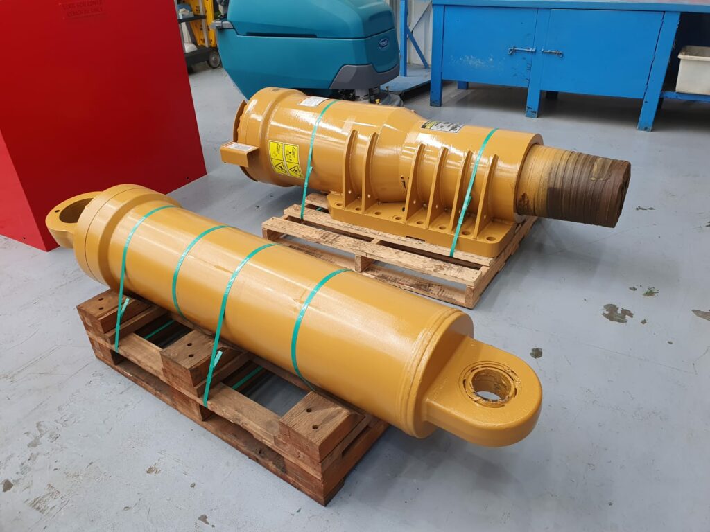 Two cylinders on wood pallet on concrete workshop floor